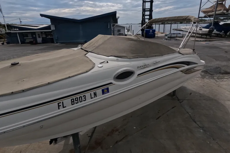 Slide: The Image of 2001 Sea Ray 240 Sundeck boat with cover, docked at marina. - 11