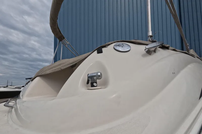 Slide: The Image of 2001 Sea Ray 240 Sundeck boat with cover, docked near blue building. - 21