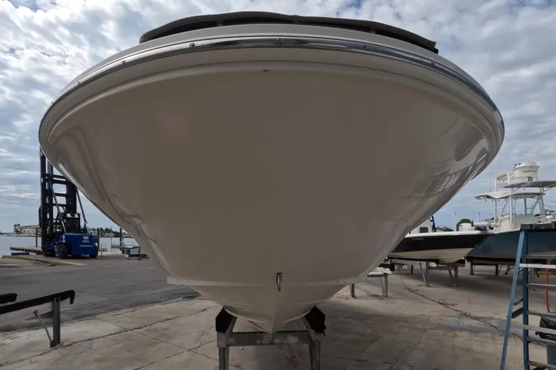 Slide: The Image of 2001 Sea Ray 240 Sundeck boat on a dock, viewed from the front. - 23