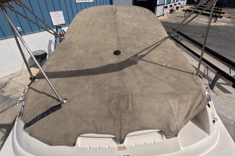 Slide: The Image of 2001 Sea Ray 240 Sundeck with protective cover in a marina setting. - 25