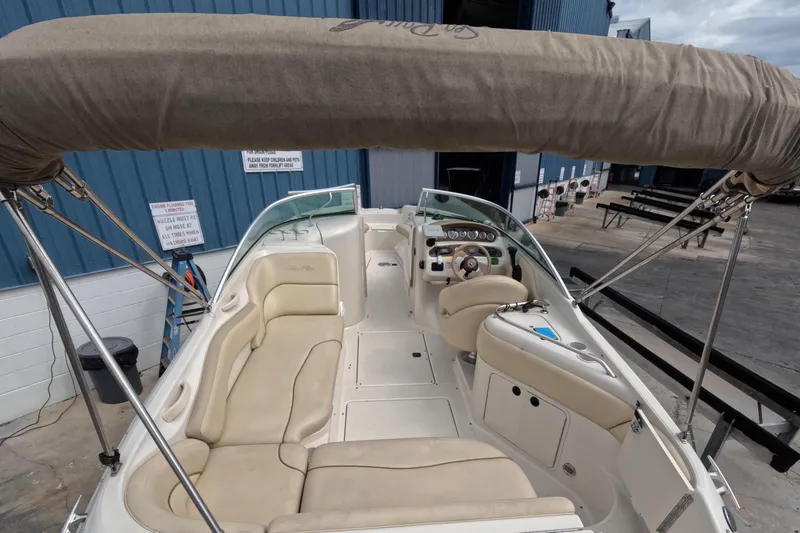 Slide: The Image of 2001 Sea Ray 240 Sundeck boat interior with beige seating and canopy. - 27