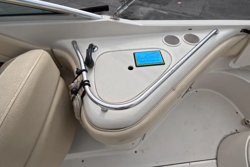 Slide: The Image of 2001 Sea Ray 240 Sundeck interior with beige seating and cup holders. - 28