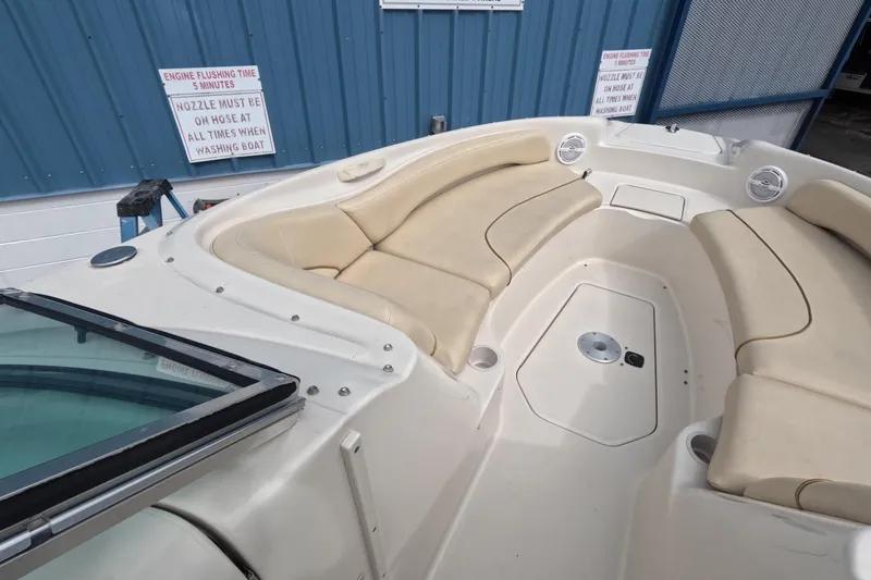Slide: The Image of 2001 Sea Ray 240 Sundeck boat interior with beige seating and blue exterior wall. - 34