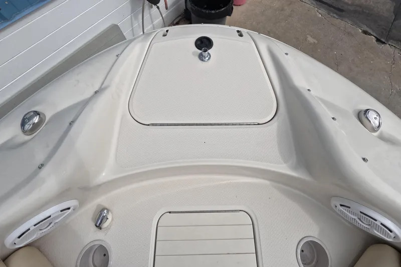 Slide: The Image of Bow area of a 2001 Sea Ray 240 Sundeck boat, featuring storage hatch and speakers. - 37