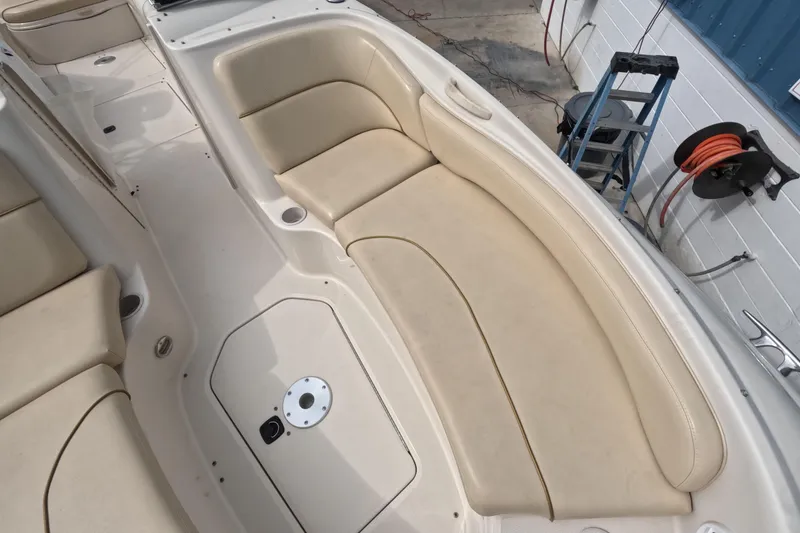 Slide: The Image of 2001 Sea Ray 240 Sundeck boat interior with beige seating and storage compartments. - 40