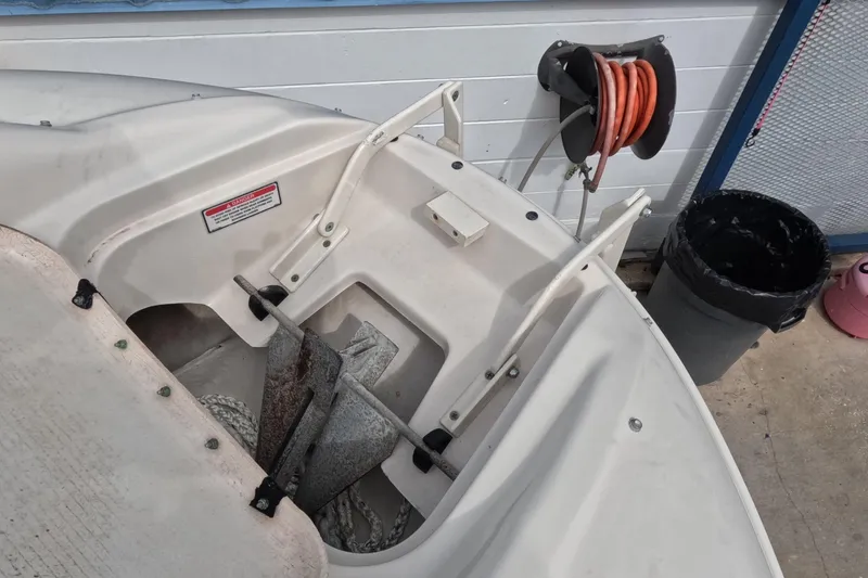 Slide: The Image of 2001 Sea Ray 240 Sundeck anchor storage area with coiled hose and trash bin nearby. - 42