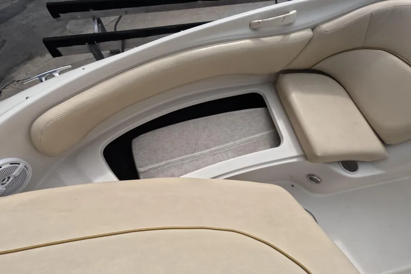 Slide: The Image of 2001 Sea Ray 240 Sundeck interior with beige seating and storage compartment. - 44
