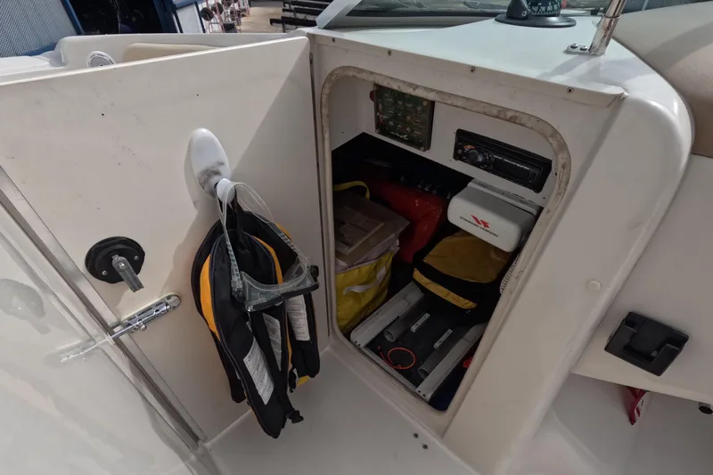 Slide: The Image of Storage compartment on a 2001 Sea Ray 240 Sundeck with life jackets and equipment. - 48