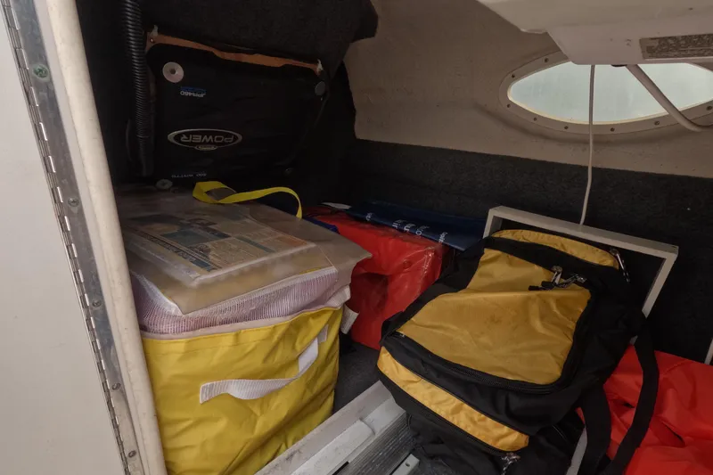 Slide: The Image of Storage area in a 2001 Sea Ray 240 Sundeck with bags and equipment. - 50