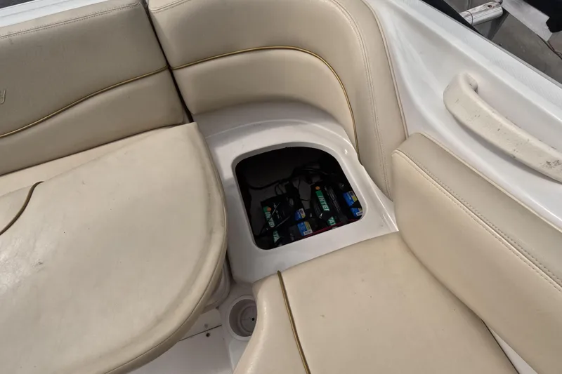 Slide: The Image of 2001 Sea Ray 240 Sundeck boat interior with battery compartment under beige seating. - 55