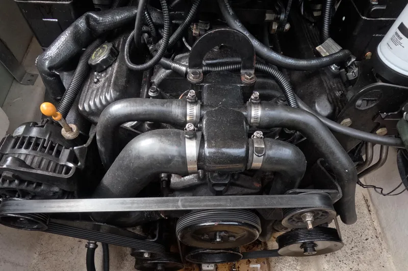 Slide: The Image of Engine of a 2001 Sea Ray 240 Sundeck boat, featuring hoses and belts. - 68