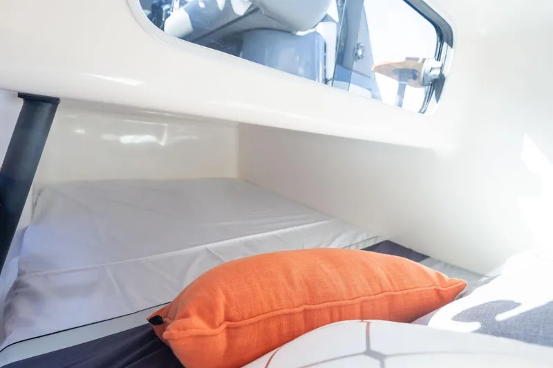 Slide: The Image of Cozy interior of 2026 Hanover 305 boat with orange pillow and window view. - 19
