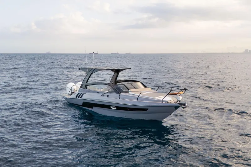 Slide: The Image of A sleek 2026 Hanover 305 boat cruising on open water under a cloudy sky. - 3