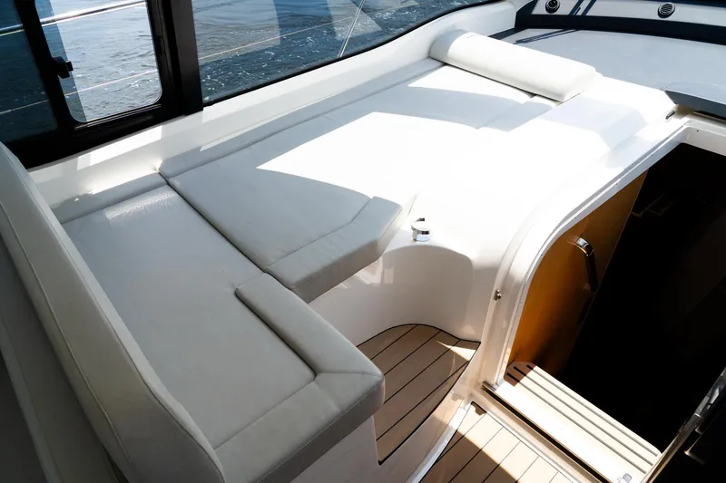 Slide: The Image of 2022 Bavaria SR41 yacht interior with white seating and wooden flooring. - 12