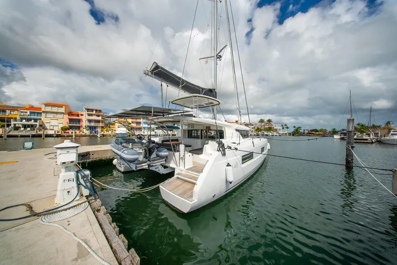 Slide: The Image of 2023 Lagoon 46 catamaran docked in a marina under cloudy skies. - 10