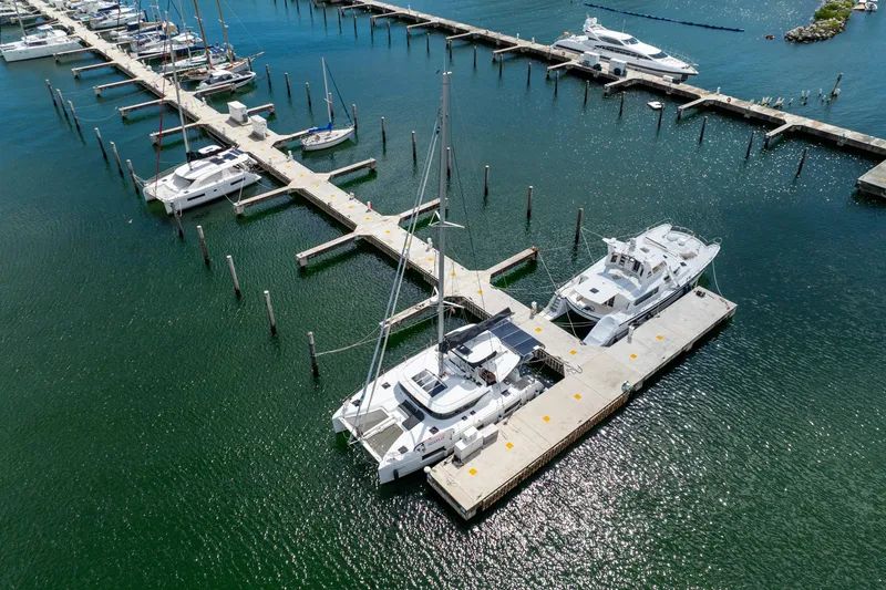 Slide: The Image of Aerial view of 2023 Lagoon 46 catamaran docked at marina with other boats. - 115