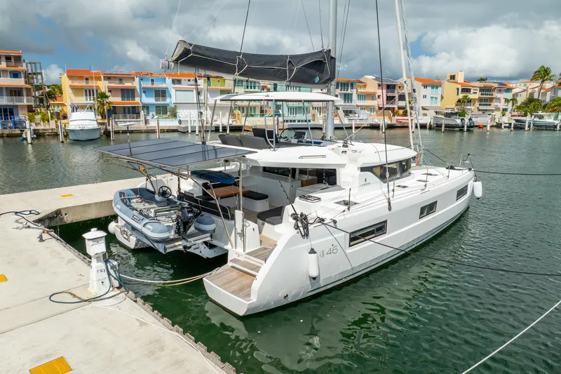 Slide: The Image of 2023 Lagoon 46 catamaran docked in a vibrant marina setting. - 122