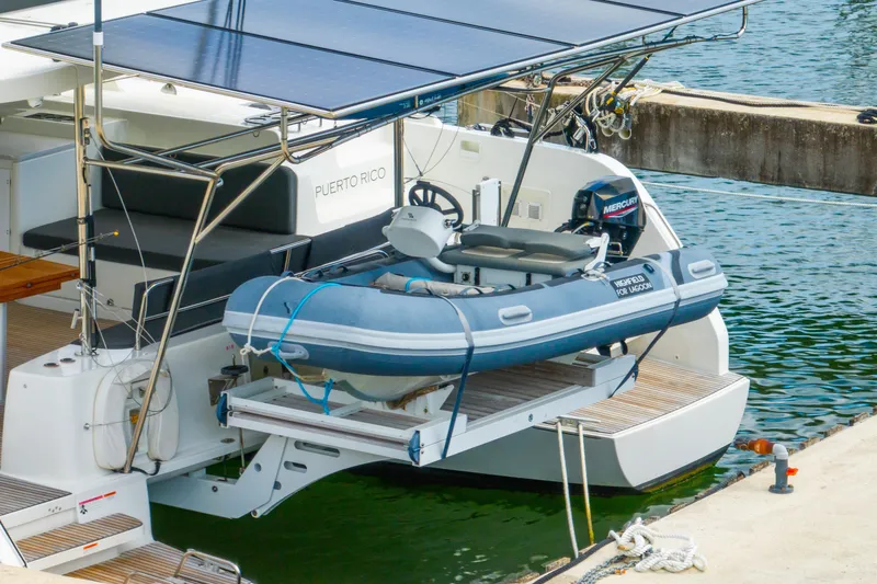 Slide: The Image of 2023 Lagoon 46 catamaran with solar panels and dinghy, docked in Puerto Rico. - 127