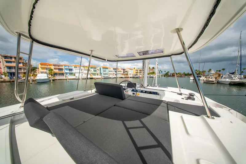 Slide: The Image of 2023 Lagoon 46 catamaran with spacious deck, docked in a vibrant marina. - 15