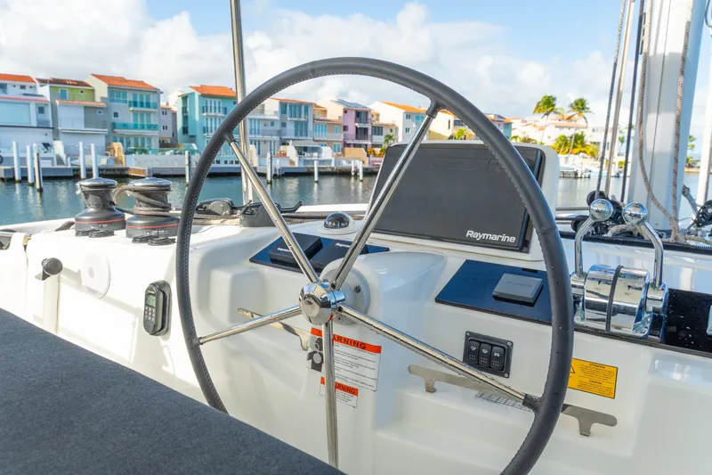 Slide: The Image of Helm of 2023 Lagoon 46 catamaran with marina view in the background. - 17