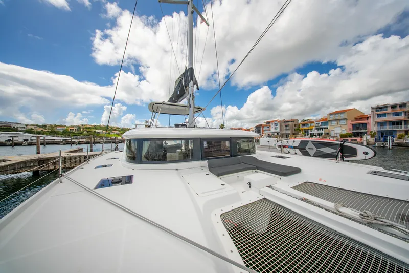 Slide: The Image of 2023 Lagoon 46 catamaran docked at marina, featuring spacious deck and modern design. - 23