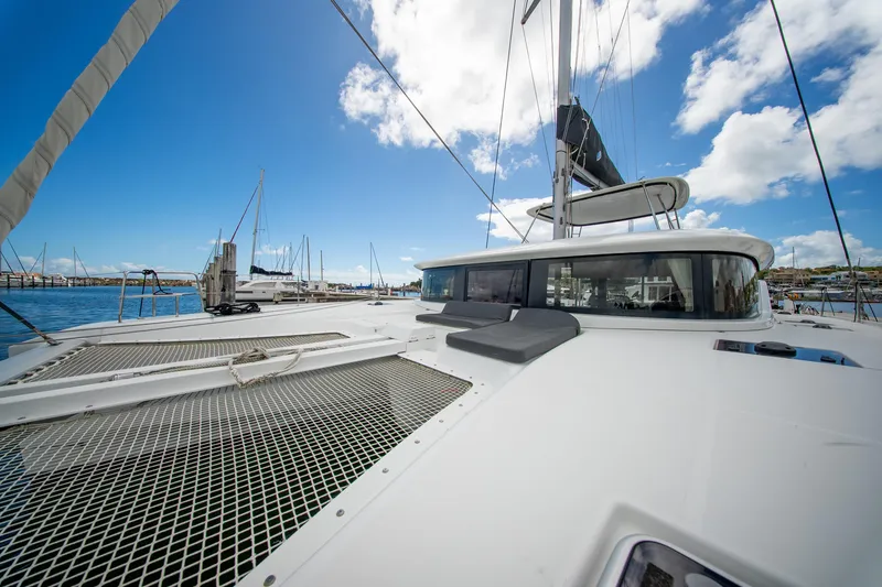 Slide: The Image of 2023 Lagoon 46 catamaran docked at marina under blue sky. - 24