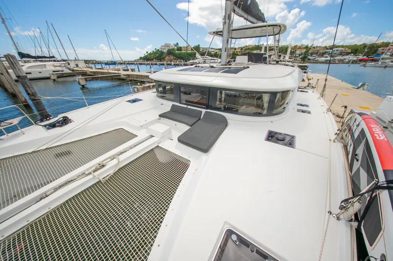 Slide: The Image of 2023 Lagoon 46 catamaran docked at marina, featuring spacious deck and modern design. - 25