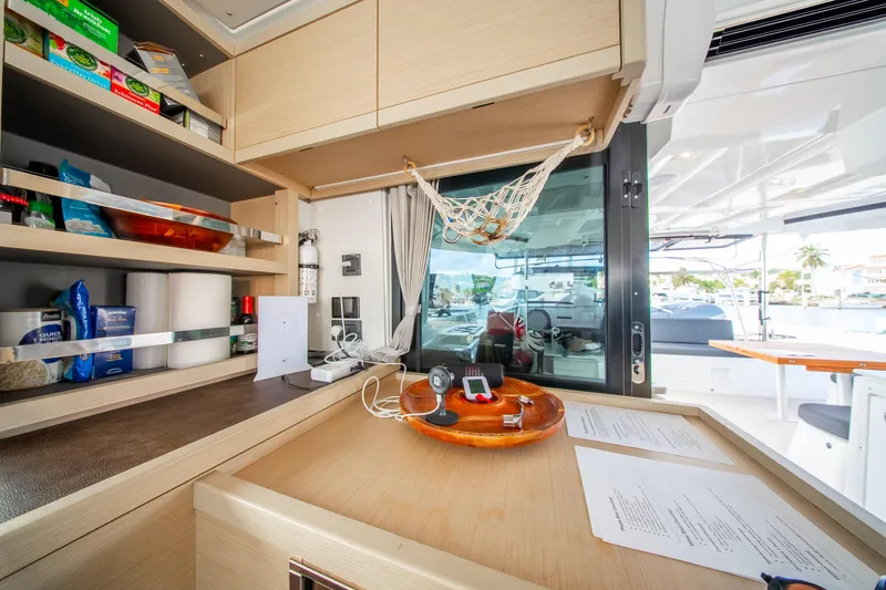 Slide: The Image of Modern kitchen area on 2023 Lagoon 46 yacht with open shelves and outdoor view. - 31
