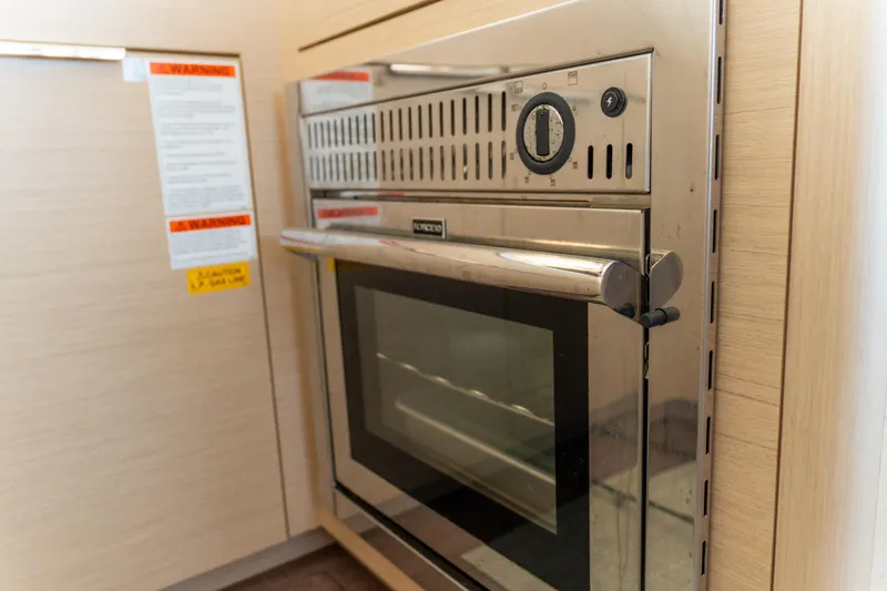 Slide: The Image of Modern oven in 2023 Lagoon 46 yacht kitchen, featuring stainless steel design and control panel. - 33