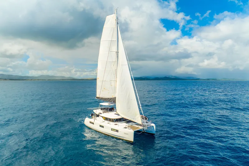 Slide: The Image of 2023 Lagoon 46 catamaran sailing on open sea under a partly cloudy sky. - 4