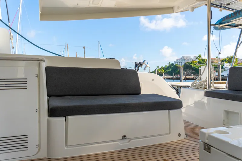 Slide: The Image of 2023 Lagoon 46 yacht interior with cushioned seating and scenic marina view. - 59
