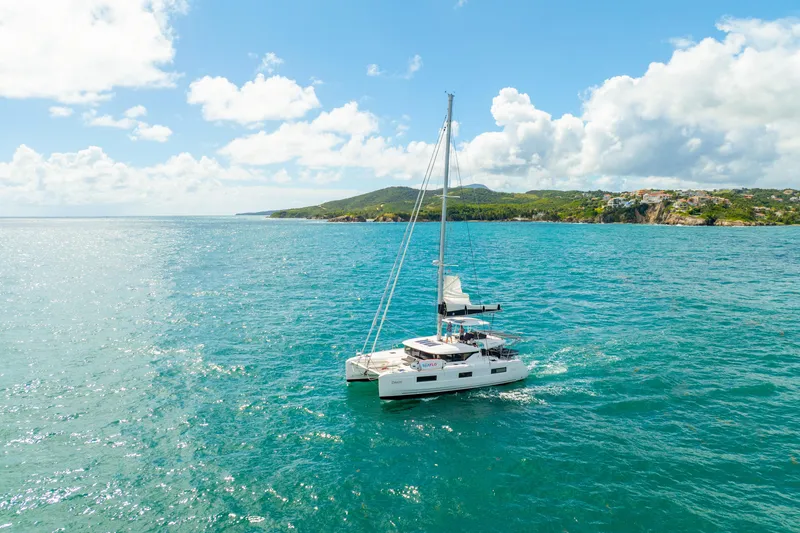 Slide: The Image of 2023 Lagoon 46 catamaran sailing on turquoise waters under a clear blue sky. - 6