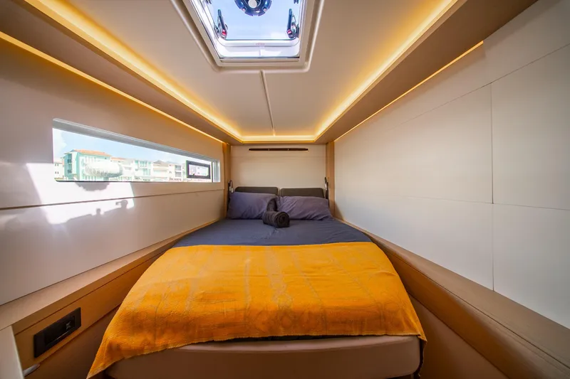 Slide: The Image of Luxurious cabin interior of 2023 Lagoon 46 yacht with modern lighting and cozy bedding. - 76