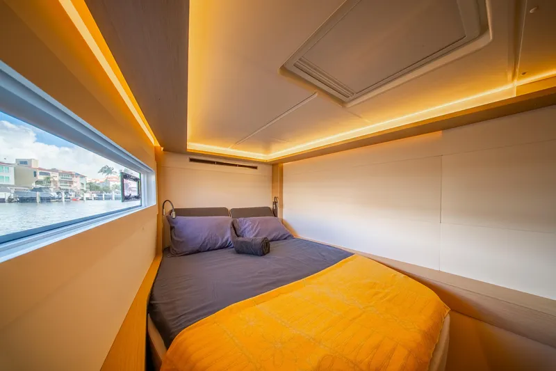 Slide: The Image of Luxurious cabin interior of 2023 Lagoon 46 yacht with cozy bedding and ambient lighting. - 77