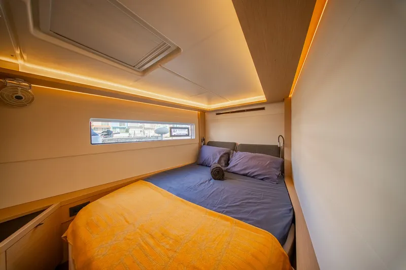 Slide: The Image of Luxurious cabin interior of 2023 Lagoon 46 yacht with cozy bedding and ambient lighting. - 78