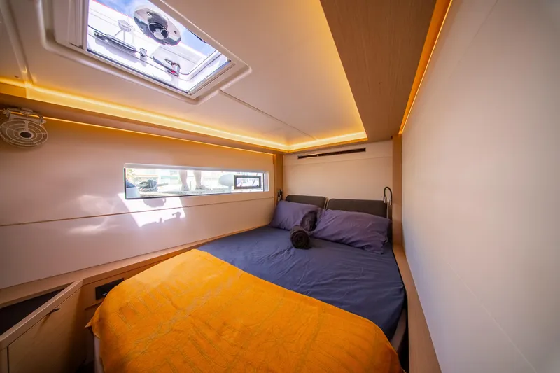 Slide: The Image of Luxurious cabin interior of 2023 Lagoon 46 yacht with cozy bedding and ambient lighting. - 79