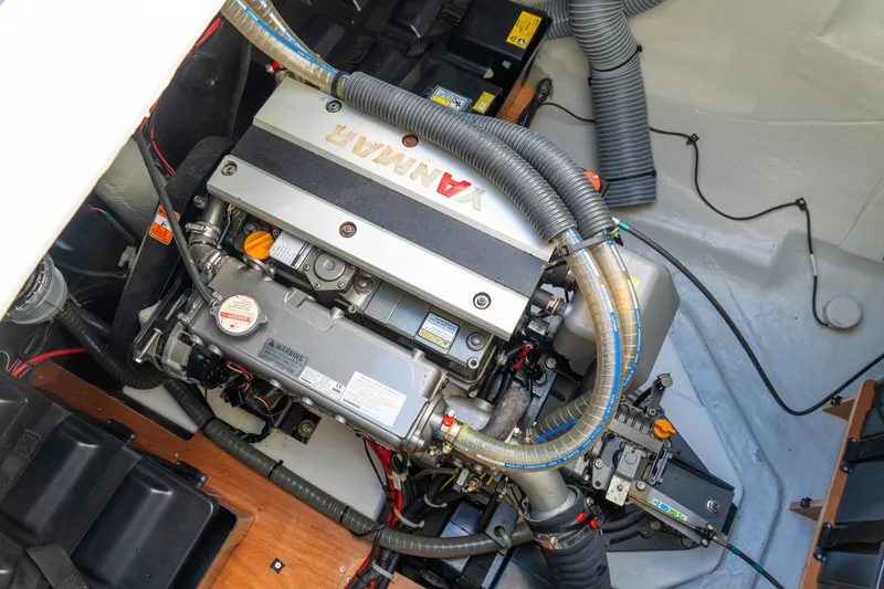 Slide: The Image of Engine compartment of 2023 Lagoon 46 yacht, featuring a Yanmar engine with visible hoses and components. - 86