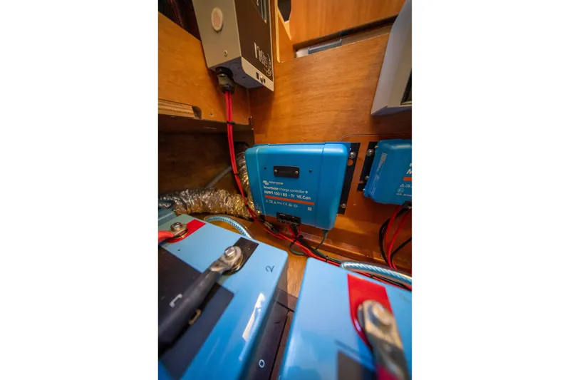 Slide: The Image of Electrical system components inside a 2023 Lagoon 46 yacht, featuring blue solar charge controllers. - 94
