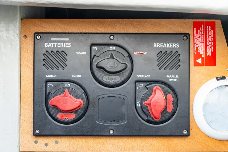 Slide: The Image of Battery and breaker panel on 2023 Lagoon 46 yacht, featuring switches and labels. - 97