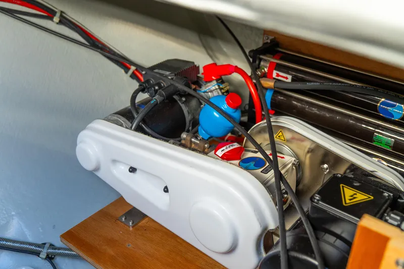 Slide: The Image of Engine compartment of 2023 Lagoon 46 yacht, showcasing mechanical components and wiring. - 99