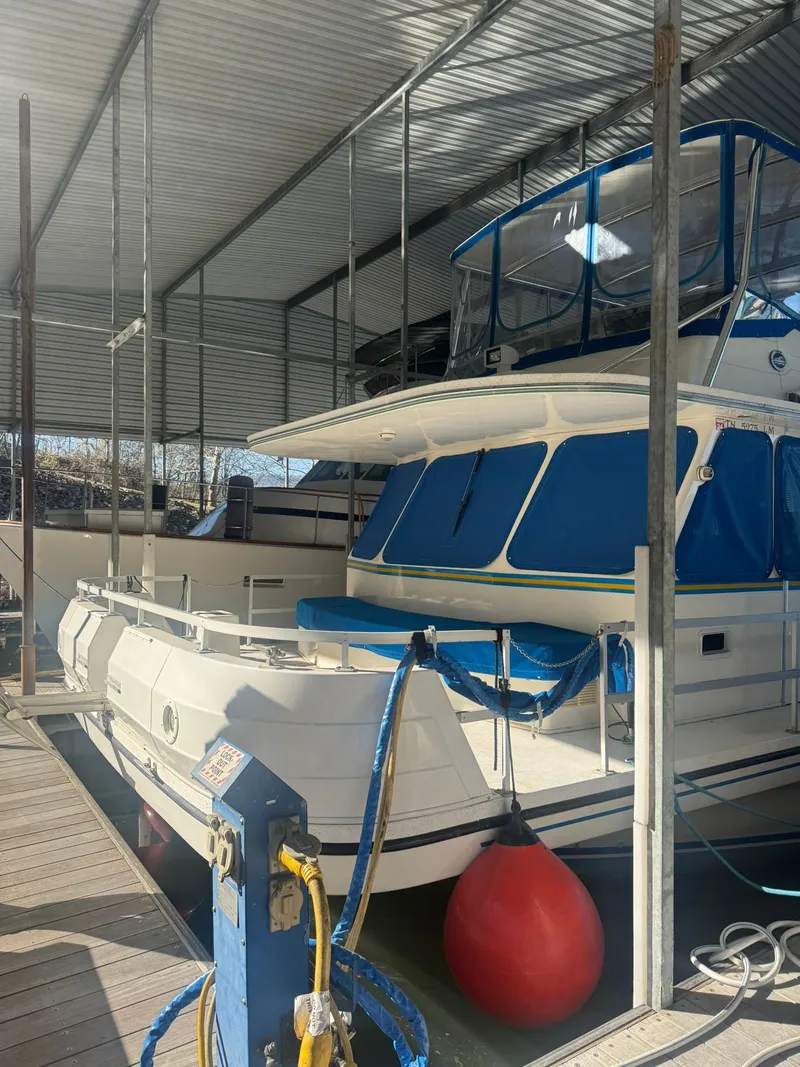 Slide: The Image of 2006 Gibson 5500 boat docked under a covered shelter. - 1