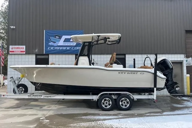 Slide: The Image of 2026 Key West 239 FSR boat on trailer, parked outside a marine dealership. - 2