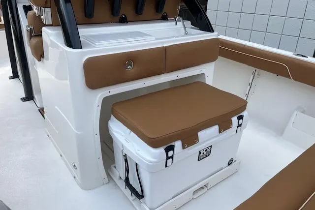 Slide: The Image of 2026 Key West 239 FSR boat interior with brown seating and cooler. - 9