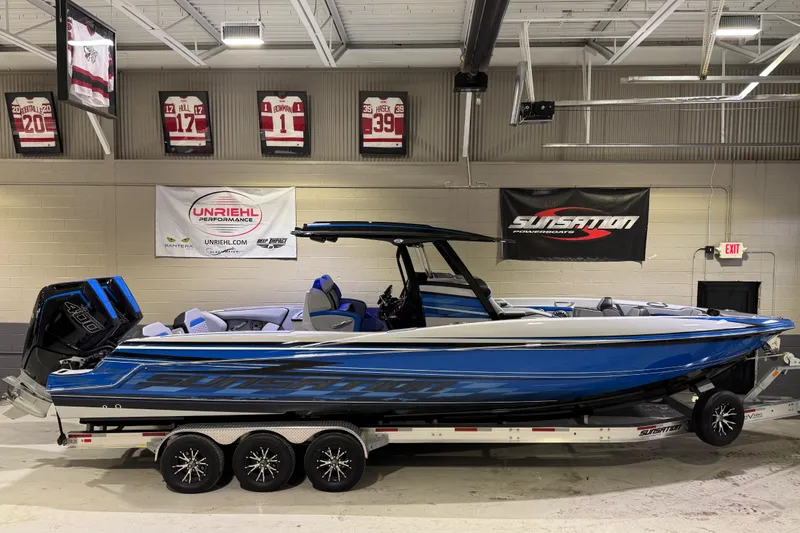 Slide: The Image of 2025 Sunsation 32 CCX boat in showroom, blue exterior, on a trailer. - 4