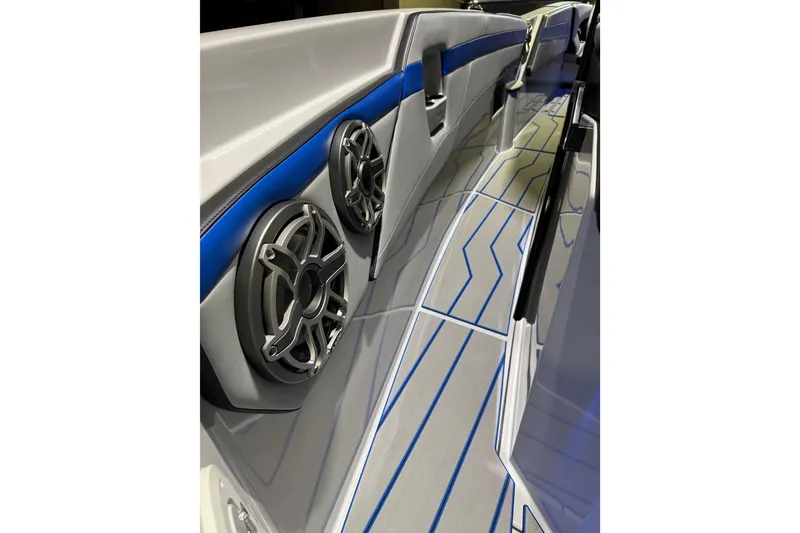 Slide: The Image of 2025 Sunsation 32 CCX boat interior with sleek design, blue accents, and modern speakers. - 8