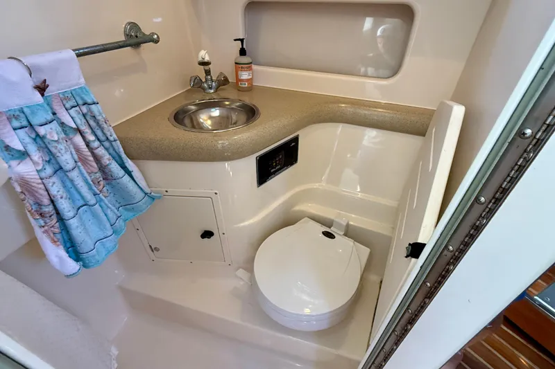Slide: The Image of Compact bathroom in 2000 Pursuit 3000 Express boat with sink and toilet. - 11