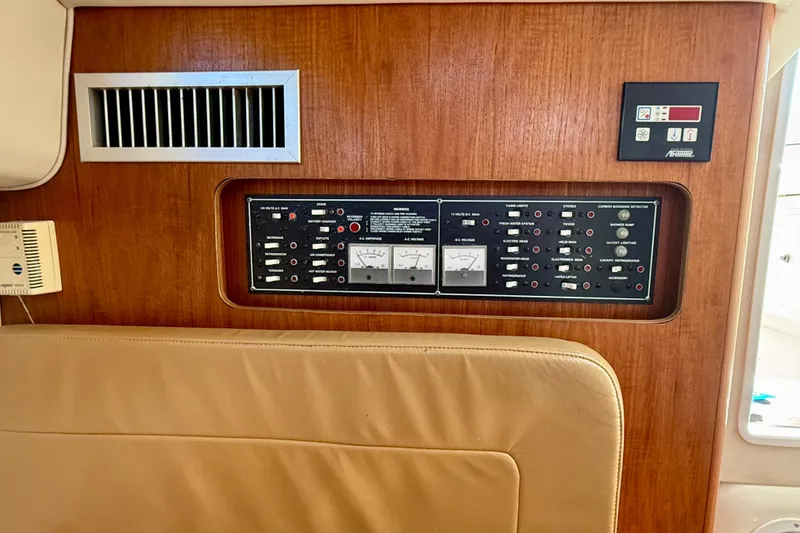 Slide: The Image of Control panel on 2000 Pursuit 3000 Express boat, featuring wood finish and ventilation. - 14