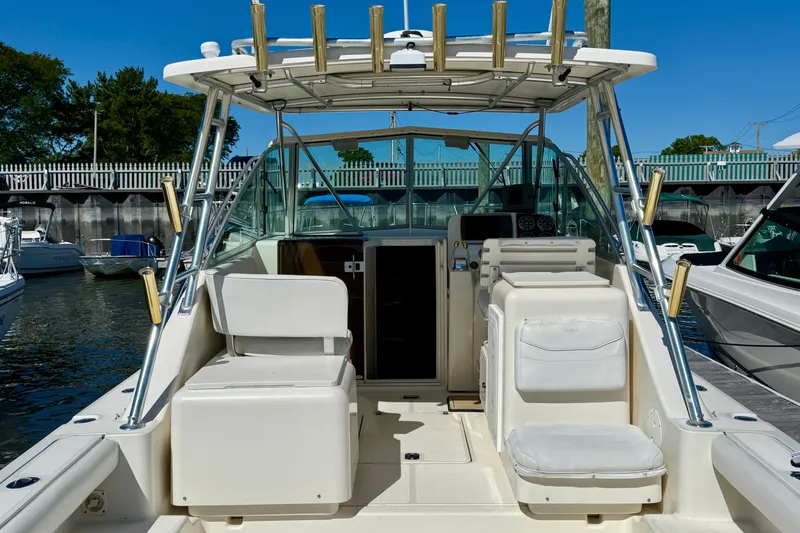 Slide: The Image of 2000 Pursuit 3000 Express boat interior with seating and helm, docked in marina. - 2