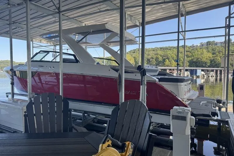 Slide: The Image of 2024 Cobalt R35 boat docked in a marina with scenic lake view. - 6