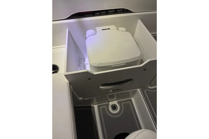 Slide: The Image of 2026 Sunsation 32 CCX boat interior with storage compartment and drain. - 20